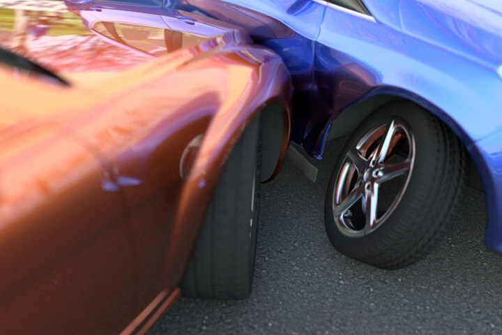 Two car accident showing damage to wheel and body panel
