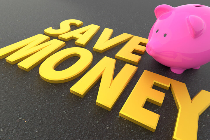 Pink piggy bank on road with words Save Money in foreground