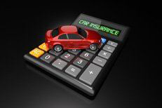 Car insurance calulator with small car Red car sitting on calculator with LCD words Car Insurance