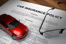 Insurance policy with glasses Car insurance policy with reading glasses on desk with red toy car