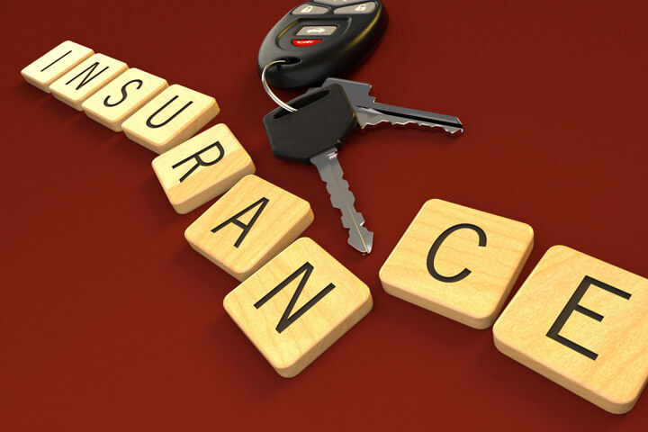 Wood insurance letters on red background with car keys