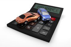 Car wreck on insurance calculator Two car accident on top of insurance calculator isolated on white