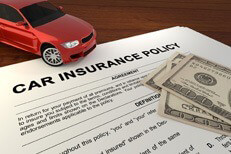 Toy car with car insurance policy and money Car insurance policy on desk with red car and one hundred dollar bills