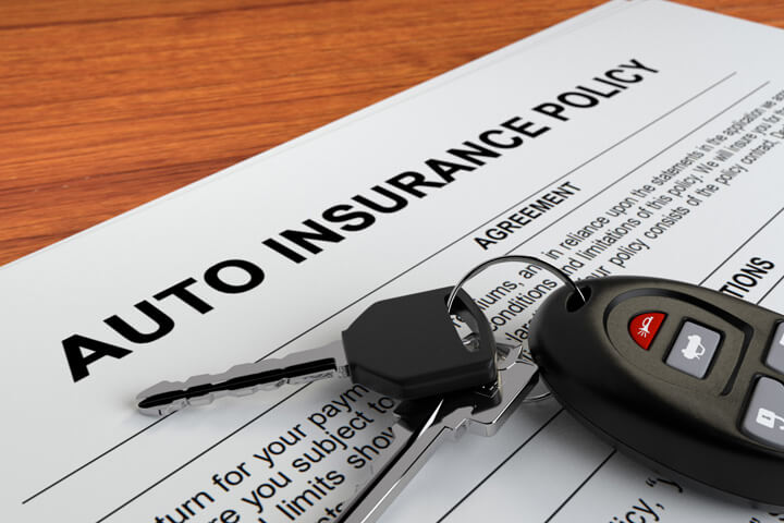 Auto insurance policy with car keys close up