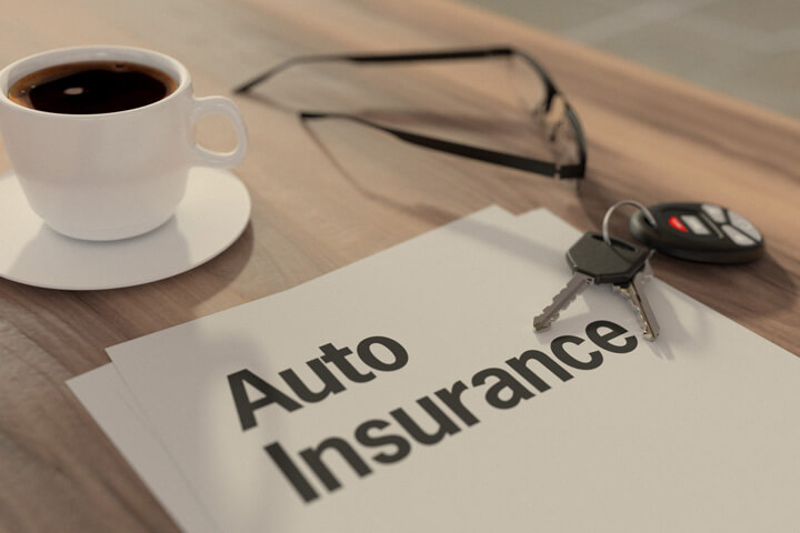 Auto insurance policy concept with glasses, car keys, and coffee on desk