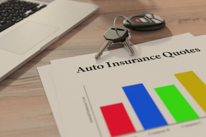 Auto insurance quotes chart on desk with car keys and laptop keyboard