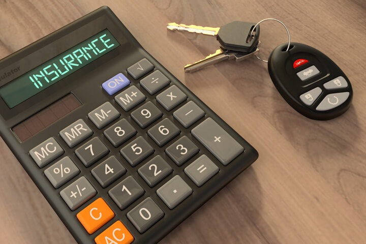 Calculator on table with Insurance LCD text next to car keys