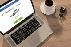 Car insurance quotes on laptop Laptop with car insurance quote website, cup of coffee, and car keys on wood table
