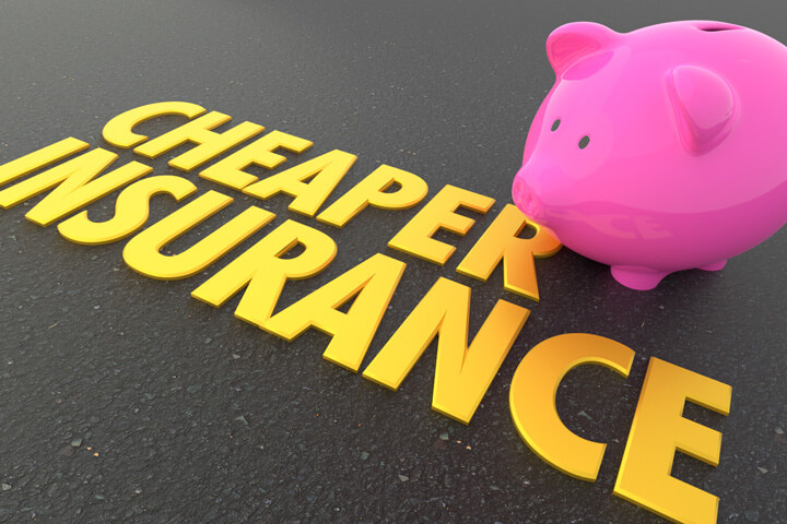 Pink piggy bank with shiny gold Cheaper Insurance words on road