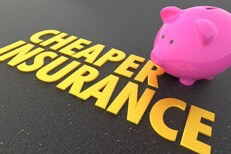 Cheaper insurance with piggy bank Pink piggy bank with shiny gold Cheaper Insurance words on road