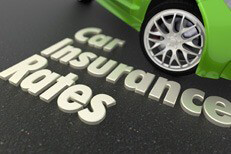 Car insurance rates on road Car insurance rates text next to green sports car on asphalt road