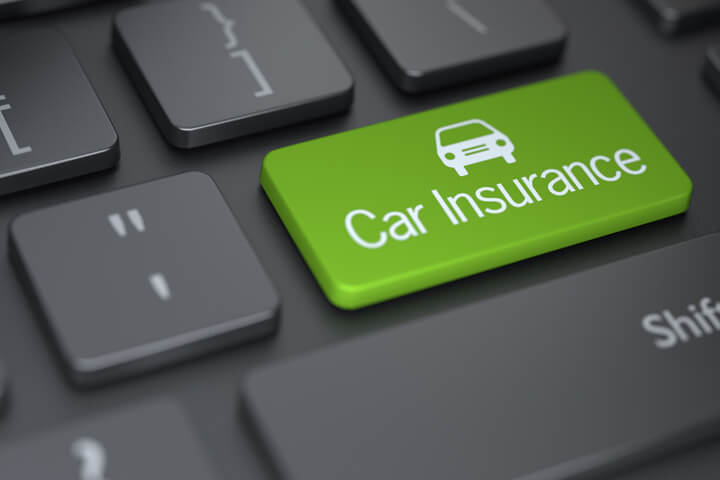 Dark laptop keyboard with green Car Insurance key with car icon concept for shopping for auto insurance online