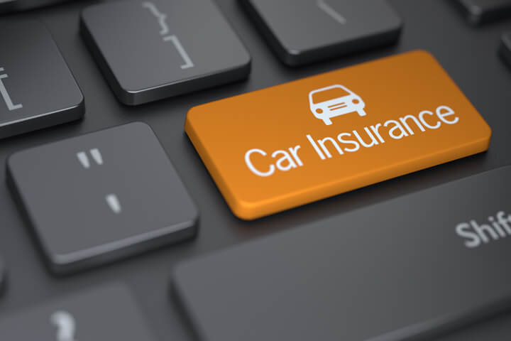 Dark laptop keyboard with orange Car Insurance key with car icon concept for comparing car insurance rates online
