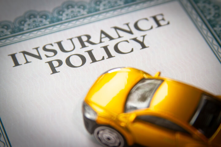 Toy car on top of insurance policy certificate with short depth of field