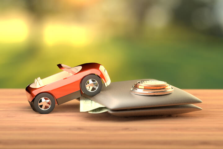 Toy car climbing wallet with coins and cash on wood table with nature backlight