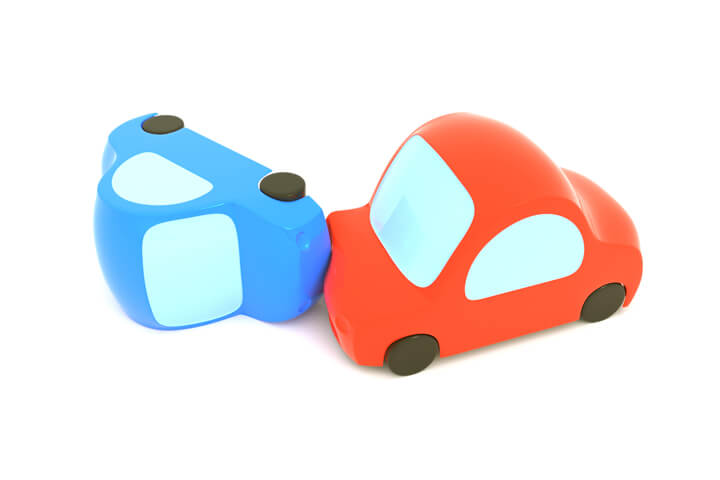Two toy cars on white background after collision and rollover