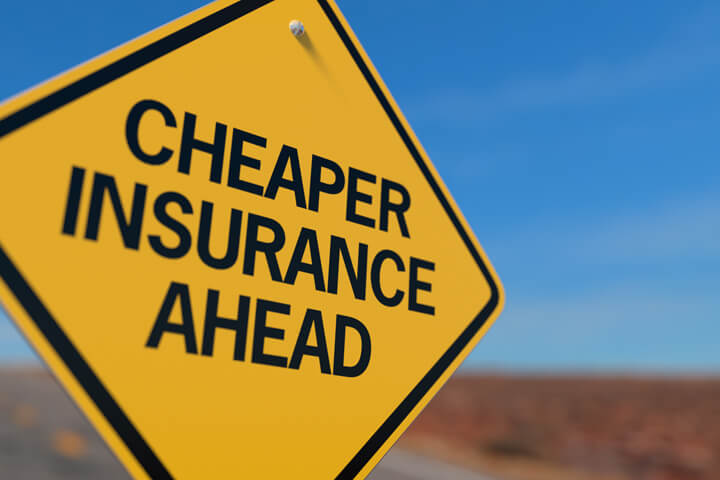 Yellow road sign reading Cheaper Insurance Ahead
