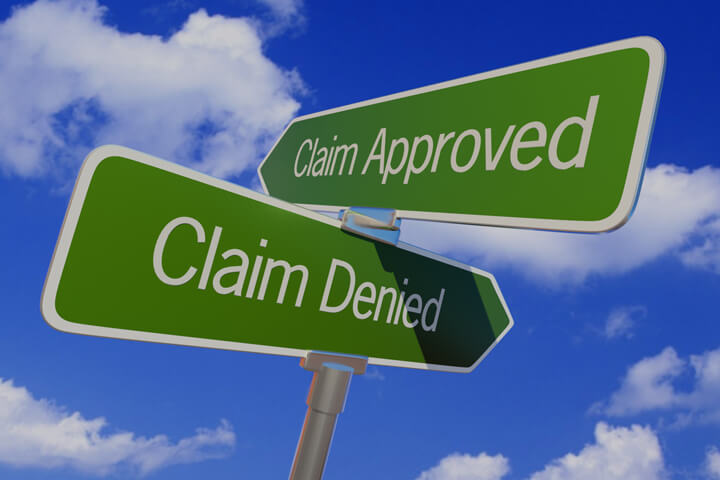 Street sign with arrows reading Claim Approved and Claim Denied pointing in opposite directions