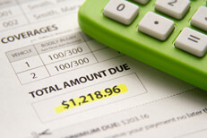 Car insurance bill with total amount due highlighted in yellow with green calculator