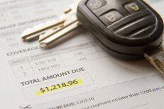 Auto insurance bill with car keys Auto insurance bill showing amount due with car keys