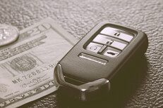 Key fob and money on leather Key fob with money on shiny leather background