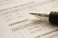 Car insurance policy with pen Car insurance policy showing coverages with ink pen