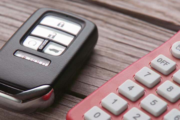 Car insurance cost concept photo of remote entry and calculator