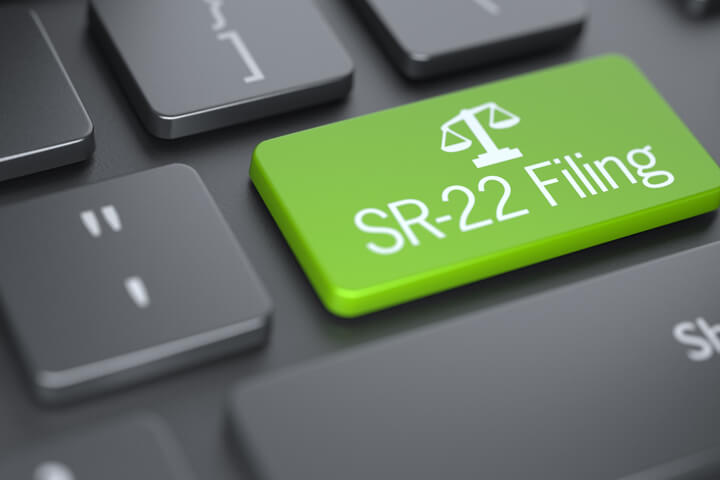 Dark laptop keyboard with green SR-22 Filing key and legal scale concept for searching for SR-22 auto insurance online