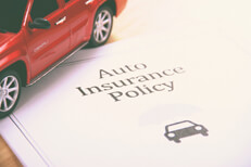 Auto insurance policy Auto insurance policy with red SUV sitting on it