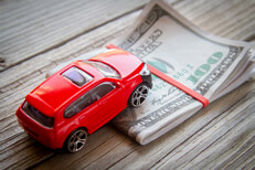 Red SUV climbing folded money Red SUV climbing folded 100 dollar bills car insurance or automotive cost concept photo