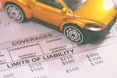 Car insurance policy showing comprehensive and collision deductibles with toy car