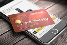 Amazon on iPhone with credit card Credit card lying on iPhone with Amazon app visible on screen online purchase concept