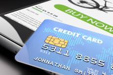 Mobile purchase with credit card Credit card resting on mobile phone showing buy now button concept for mobile purchase