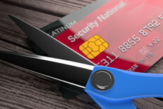 Cut up credit cards Two credit cards with scissors on weathered wood background