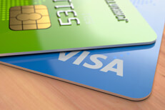 Two credit cards on desk Blue and green credit cards with EMV chip on wood desk