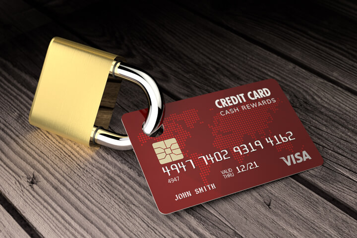 Red credit card padlocked on old wood surface