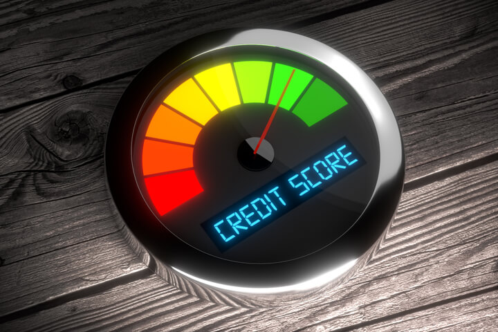 Chrome credit score gauge on weathered wood planks showing good credit rating
