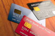 Angled view of three credit cards Angled view of three credit cards on rich wood desk or table