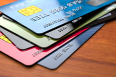 Stack of credit cards Stack of shiny credit cards on rich wood surface