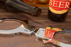 Beer bottles and hand cuffs Beer bottles on bar with hand cuffs concept for DUI or drunk driving arrest