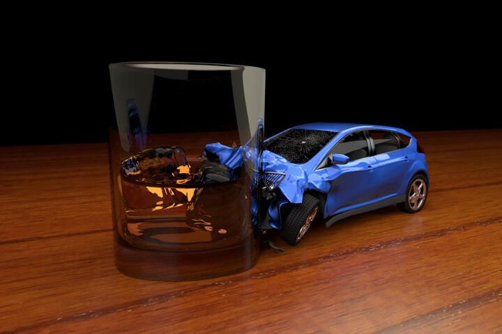 Drunk driving concept of small car crashed into glass of whiskey on bar table
