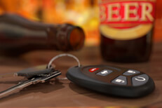 Car keys at happy hour Car keys and clicker with beer bottles on bar at happy hour DUI concept image