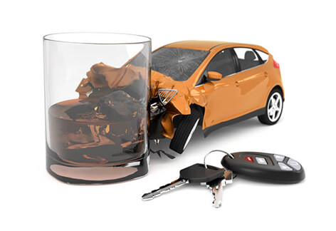 Orange car smashed into drink with car keys Orange compact car smashed into whiskey glass with car keys and key fob