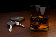 Glass of whiskey next to car keys on bar Drunk driving concept white car keys and drink on bar