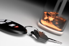Whiskey glass and car keys on white Drunk driving concept showing whiskey glass and car keys on white studio background
