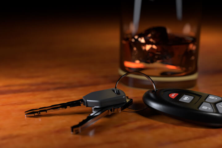 DUI concept showing whiskey glass and car keys on bar top