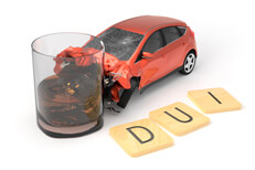 DUI accident with red car and wood letters spelling DUI in foreground