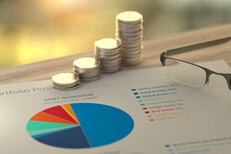 Stacks of coins with asset allocation pie chart Desk photo of portfolio assets with stacks of coins representing investment growth over time