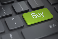 Laptop keyboard with green Buy key Dark computer keyboard with large green Buy button representing online shopping or buying online