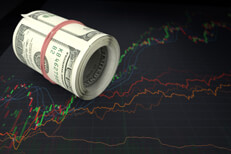 Large money roll on stock chart Large roll of U.S. bills laying on top of line charts showing massive stock price fluctuation